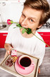 Young man with rose in mouth