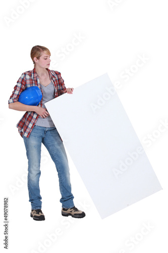 Photo: Female builder holding poster Female builder holding poster