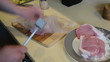 hand with metal hammer beat meat covered with polyethylene film