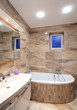 bathroom in luxury home with bath and furniture