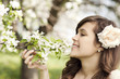 Happy young woman enjoying the fragrance of flowers