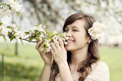 Photo: Happy young woman enjoying the fragrance of flowers Happy young woman enjoying the fragrance of flowers