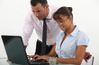 businessman and his assistant looking at a laptop