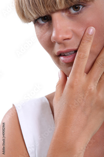 Photo: Young woman with her hand to her face Young woman with her hand to her face