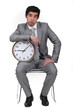 Businessman bored with alarm clock