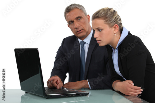 Photo: businessman and businesswoman analysing data on their laptop businessman and businesswoman analysing data on their laptop