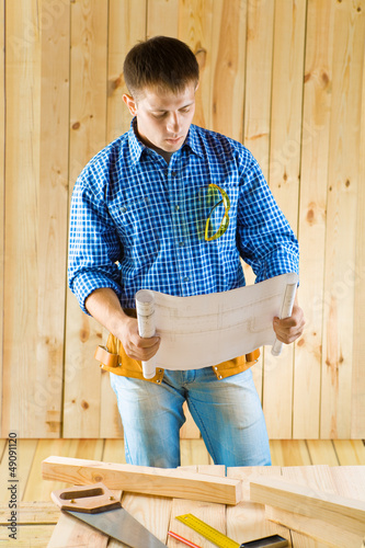 Photo: carpenter looks on blueprint carpenter looks on blueprint