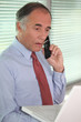 mature businessman on the phone looks stunned