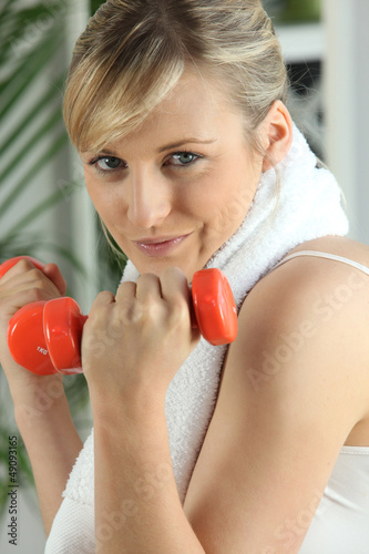 Photo: Blond lifting weights in gym Blond lifting weights in gym