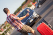 Young Man Hitchhiking along the Road
