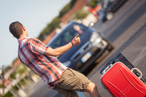 Photo: Young Man Hitchhiking along the Road Young Man Hitchhiking along the Road