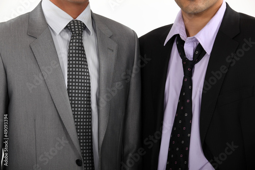 Photo: One executive with a perfect tie, another with a loosened tie One executive with a perfect tie, another with a loosened tie