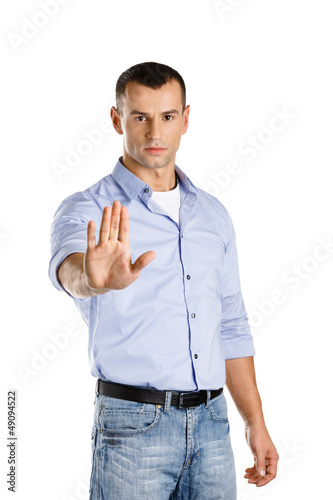 Photo: Serious man shows stop gesture, isolated on white Serious man shows stop gesture, isolated on white