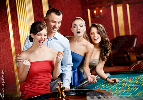Photo: Group of young people playing roulette at the gambling house Group of young people playing roulette at the gambling house