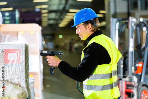 Photo: Warehouseman in protective vest using a scanner Warehouseman in protective vest using a scanner