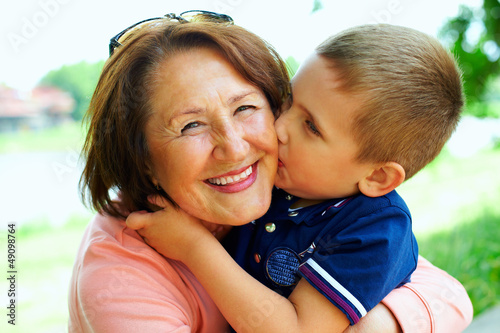 Photo: happy grandma with grandson embracing outdoor happy grandma with grandson embracing outdoor