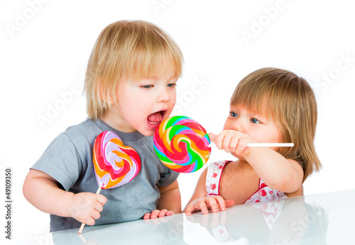 Photo: Babies eating a sticky lollipop Babies eating a sticky lollipop