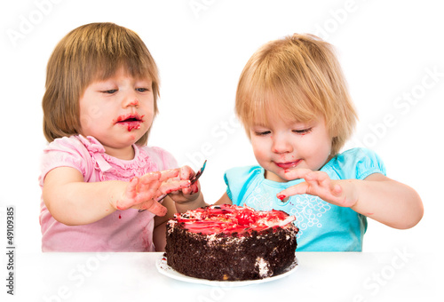 Photo: Two little baby girl eating cake Two little baby girl eating cake