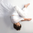 Woman in fetal position on white background