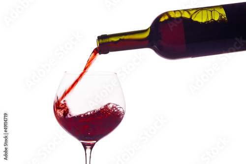 Photo: Rotwein wird in ein Weinglas eingegossen Rotwein wird in ein Weinglas eingegossen