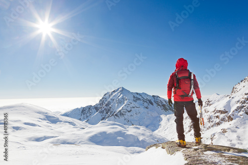 Photo: Mountaineer looking at a snowy mountain landscape Mountaineer looking at a snowy mountain landscape