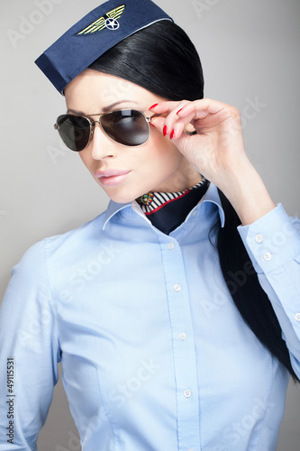 Photo: Young attractive stewardess with aviator sunglasses Young attractive stewardess with aviator sunglasses