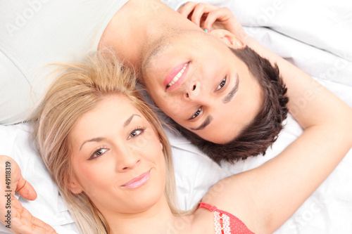 Photo: Close-up shot of a young couple laying in a bed Close-up shot of a young couple laying in a bed