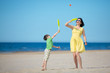 Young mother and son playing on the beach