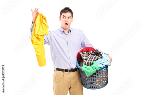 Photo: Man holding a smelly blouse and a laundry basket Man holding a smelly blouse and a laundry basket