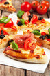 Pizza with ham, pepper and olives on old wooden background