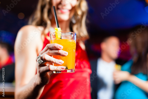 Photo: Woman with cocktail in bar or club Woman with cocktail in bar or club