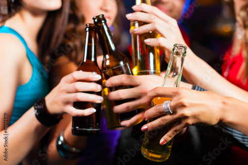 Photo: People drinking beer in bar or club People drinking beer in bar or club