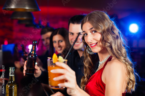 Photo: People with cocktails in bar or club People with cocktails in bar or club