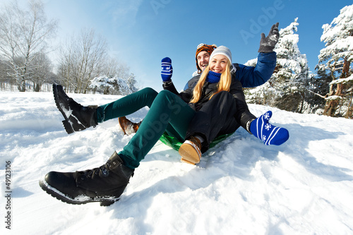 Photo: young happy couple sledding in winter young happy couple sledding in winter
