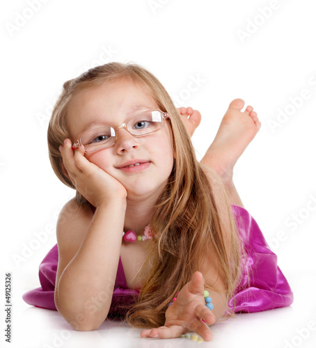Photo: Happy little girl laying on floor isolated Happy little girl laying on floor isolated