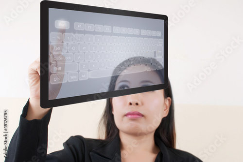 Photo: business lady pushing transparent keyboard business lady pushing transparent keyboard