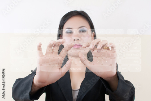 Photo: business lady pushing transparent keyboard business lady pushing transparent keyboard