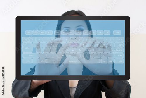 Photo: business lady pushing transparent keyboard business lady pushing transparent keyboard