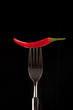 Foto: a fresh red chili on a black background a fresh red chili on a black background