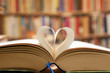 Book page in heart shape with library background