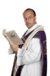 katholischer Priester mit Bibel im Gottesdienst