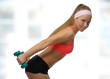 Image of blonde smiling woman with barbell in hand