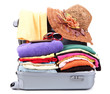 Open silver suitcase with clothing isolated on white