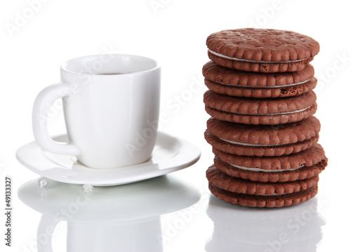 Photo: Chocolate cookies with creamy layer and cup of coffe isolated Chocolate cookies with creamy layer and cup of coffe isolated