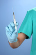 Doctor with syringe  on blue background