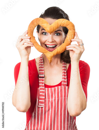 Photo: Happy woman looking through bread love heart Happy woman looking through bread love heart