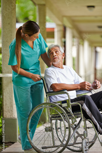 Photo: Krankenschwester redet mit Mann im Rollstuhl Krankenschwester redet mit Mann im Rollstuhl