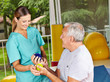 Senior mit Igelball bei Physiotherapie