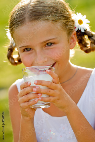 Photo: Health, diet - lovely girl drinking fresh milk outdoors Health, diet - lovely girl drinking fresh milk outdoors