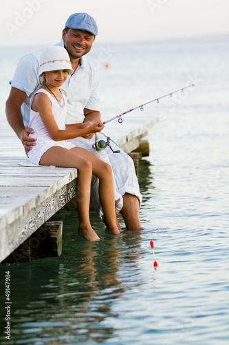 Photo: Fishing - girl with father fishing on the pier Fishing - girl with father fishing on the pier